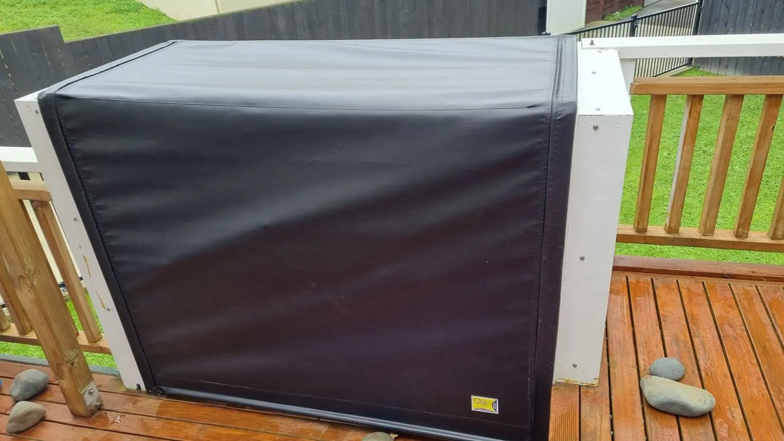Black PVC cover fitted over a built-in BBQ island on a deck