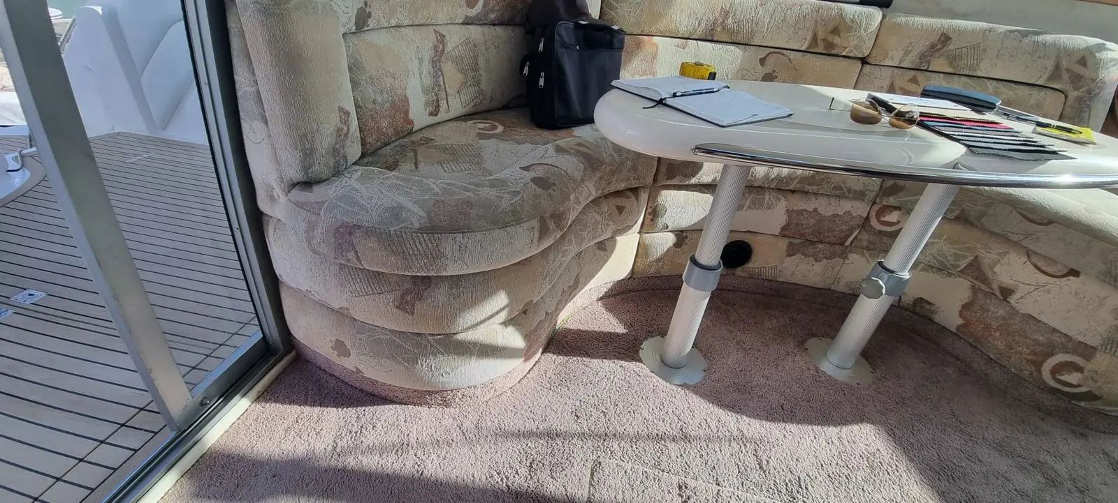 Worn patterned saloon seating in a launch before reupholstery