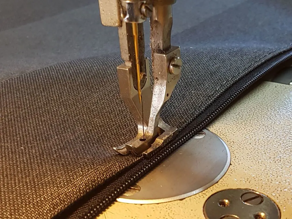 Industrial sewing machine stitching a zip into marine canvas