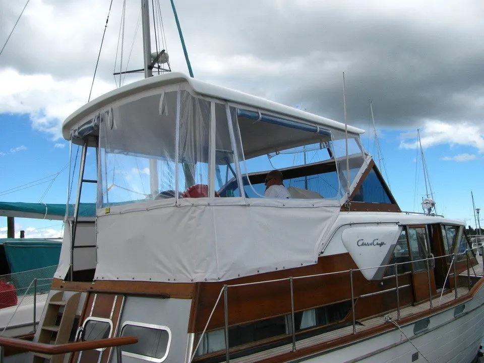 Custom fitted white boat cover on a classic Chris Craft launch at an Auckland marina