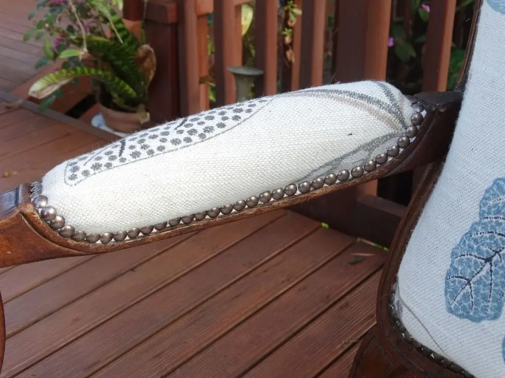 Brass stud detail on reupholstered chair arm