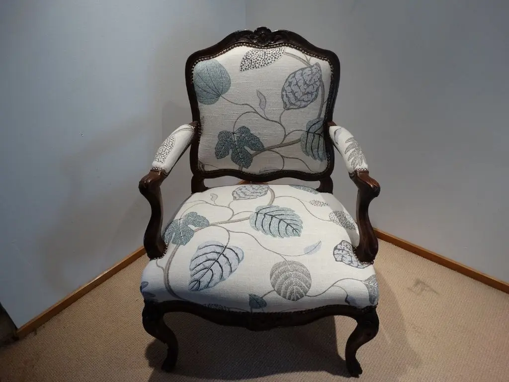 Front view of reupholstered antique armchair