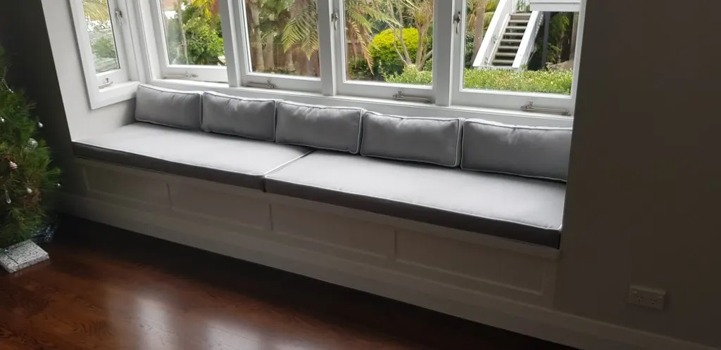 Custom grey window seat squabs with piped bolster cushions