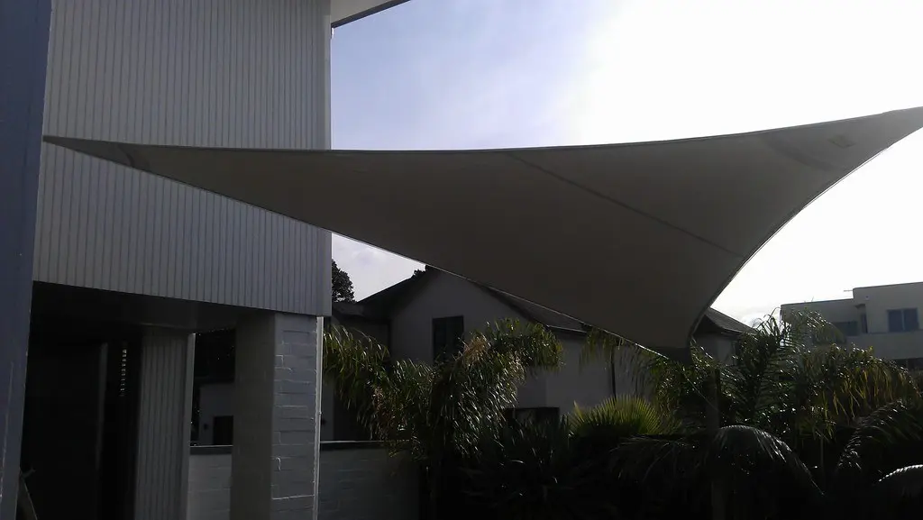 Triangular shade sail over a modern patio
