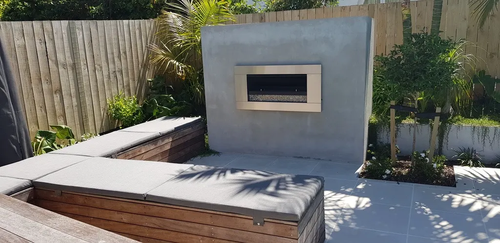 Grey outdoor squabs on built-in seating beside an outdoor fireplace