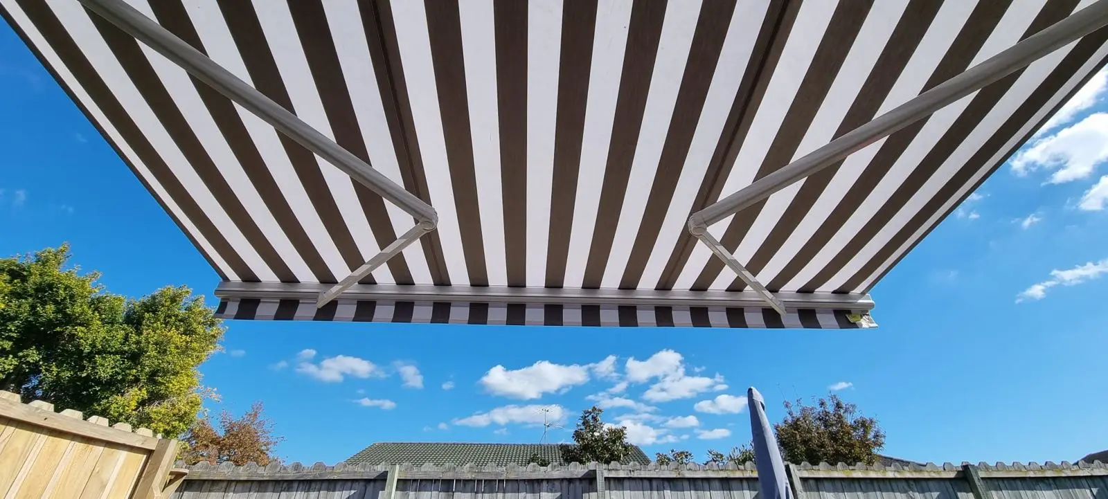 Black and white striped retractable awning recovered