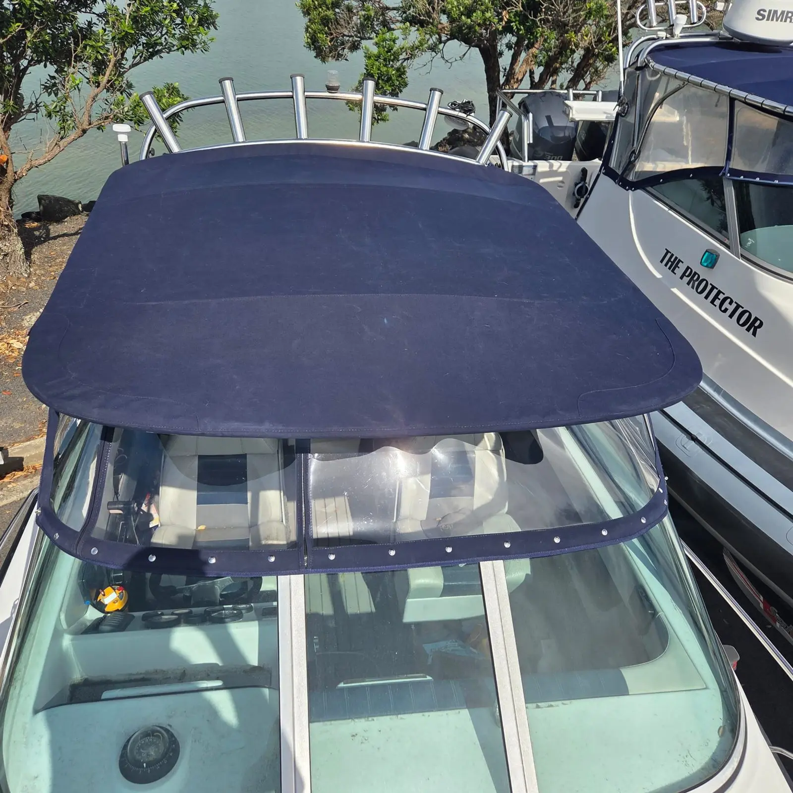 Navy bimini top fitted over a boat cockpit at the marina
