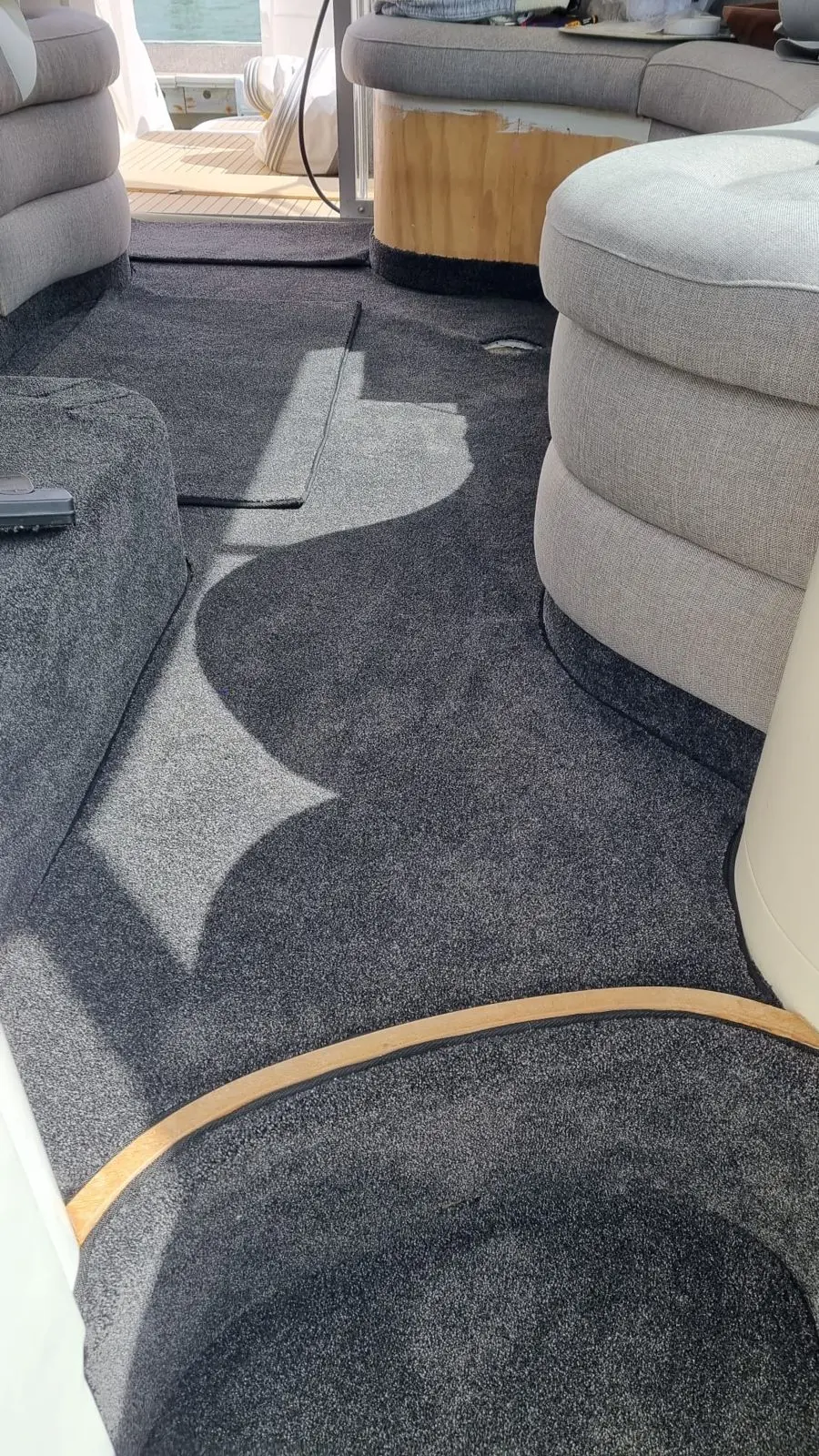 New grey bound-edge carpet fitted through a boat cockpit