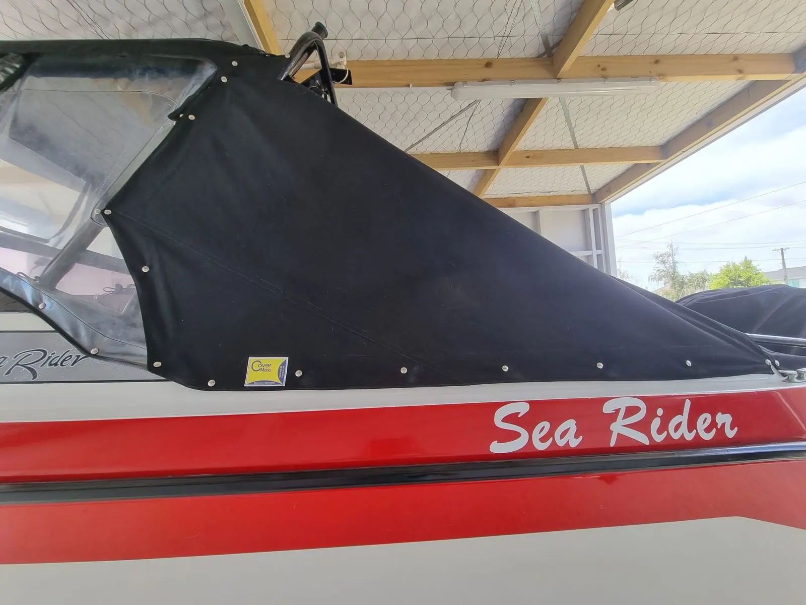 Fitted black cover on a red Sea Rider runabout