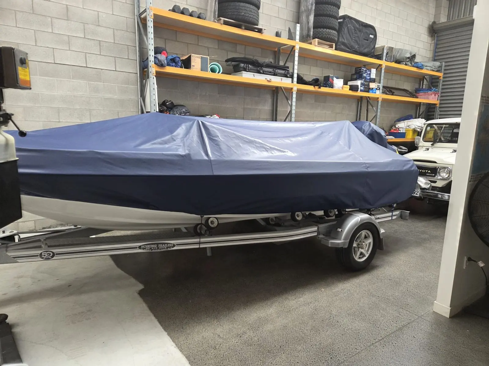 Navy fitted cover on a trailered boat in the workshop