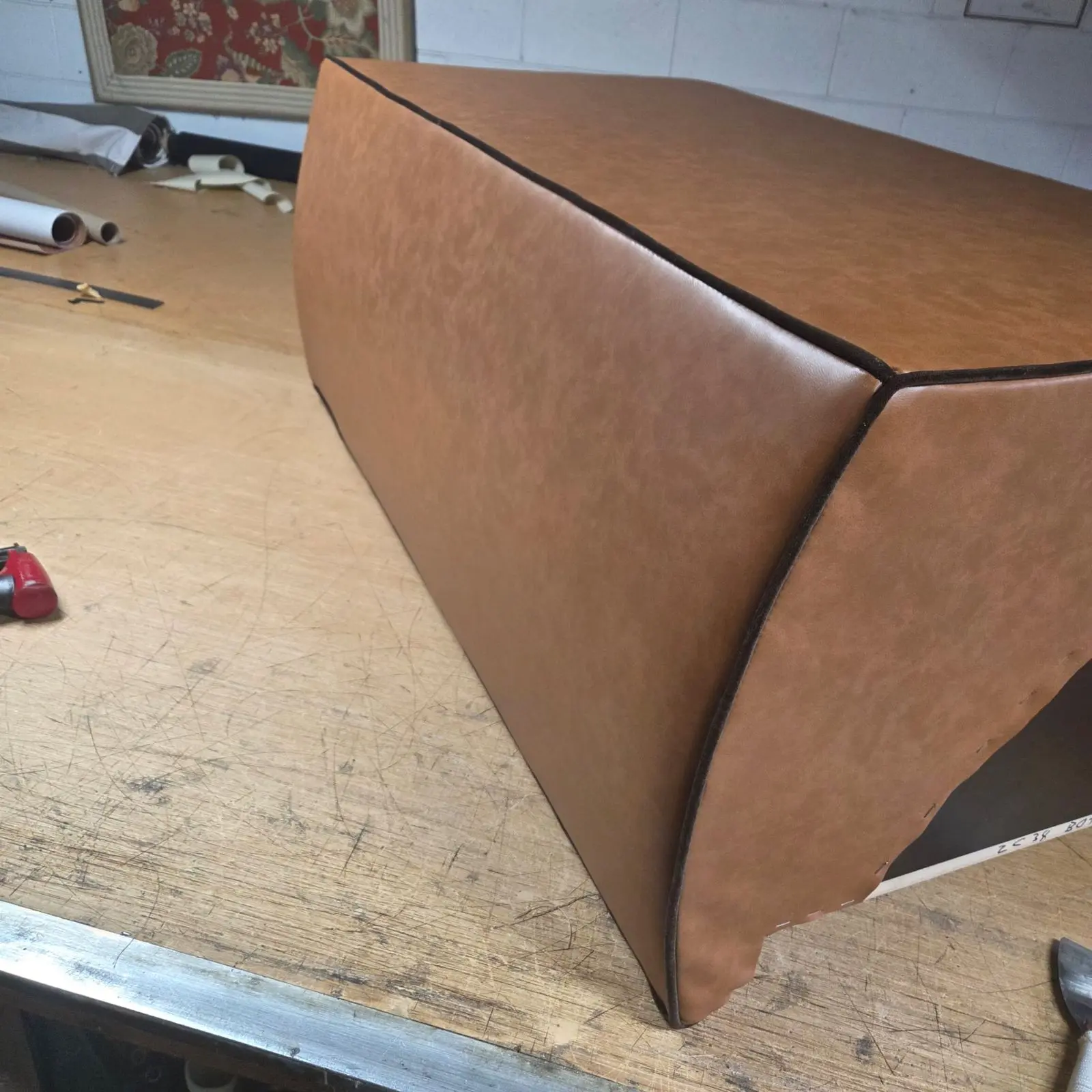 Tan leather boxed corner detail on the workshop bench