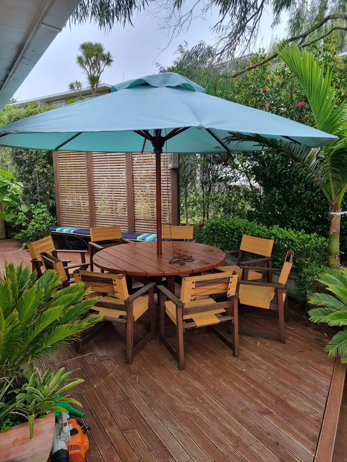 Deck umbrella with a new green made-to-measure canopy over outdoor furniture